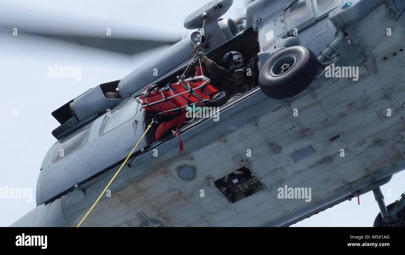 Ein Naval Air Crewman auf der "Insel der Ritter" Hubschrauber Meer Combat Squadron (HSC) 25 senkt ein Wurf von einem MH-60S Sea Hawk Hubschrauber ein Mark VI Patrouillenboot bei einer gemeinsamen Suche und Rettung Übung mit Küsten Riverine Squadron 4, Det zugeordnet. Guam und der U.S. Coast Guard Sektor Guam, 24.02.23. HSC-25 unterhält eine 24-Std.-Suche und Rettung und medizinische Evakuierung alert Haltung, die direkte Unterstützung der US-Küstenwache, Sektor Guam und gemeinsame Region Marianas. (U.S. Marine Foto von Mass Communication Specialist 3. Klasse Heather C. Wamsley/Freigegeben) Stockfoto