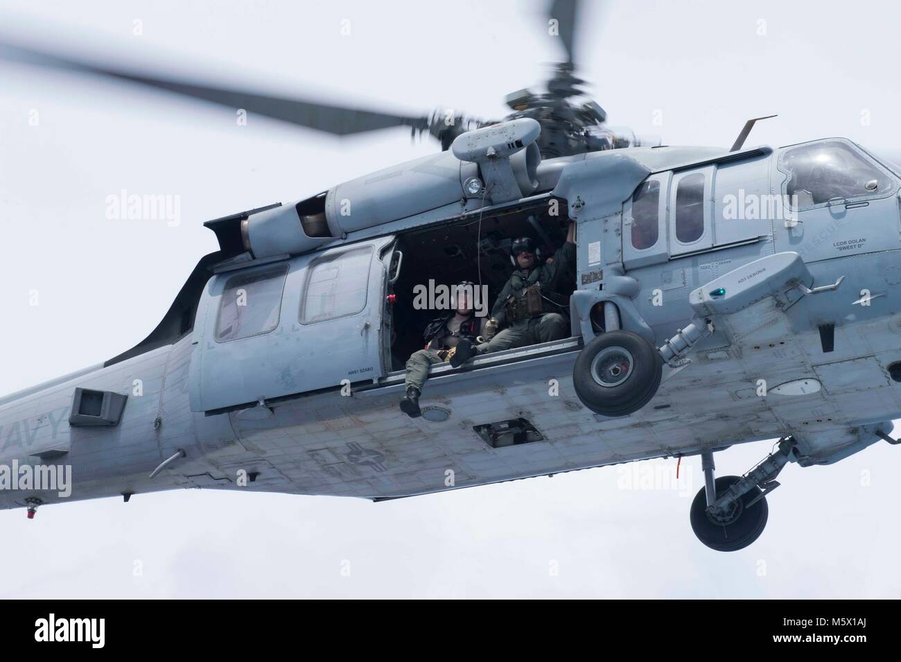 Naval Air Besatzungsmitglieder auf der "Insel der Ritter" Hubschrauber Meer Combat Squadron (HSC) 25 fly in einem MH-60S Sea Hawk Hubschrauber während einer gemeinsamen Suche und Rettung Übung mit Küsten Riverine Squadron 4, Det zugeordnet. Guam und der U.S. Coast Guard Sektor Guam, 24.02.23. HSC-25 unterhält eine 24-Std.-Suche und Rettung und medizinische Evakuierung alert Haltung, die direkte Unterstützung der US-Küstenwache, Sektor Guam und gemeinsame Region Marianas. (U.S. Marine Foto von Mass Communication Specialist 3. Klasse Heather C. Wamsley/Freigegeben) Stockfoto