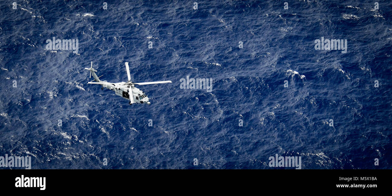 Ein MH-60S Sea Hawk Hubschrauber, auf der "Insel der Ritter" Hubschrauber Meer Combat Squadron (HSC) 25, führt eine Suche und Rettung Übung vor der Küste von Guam, Feb 23, 2018 zugeordnet. HSC-25 unterhält eine 24-Std.-Suche und Rettung und medizinische Evakuierung alert Haltung, die direkte Unterstützung der US-Küstenwache, Sektor Guam und gemeinsame Region Marianas. (U.S. Marine bekämpfen Kamera Foto von Mass Communication Specialist 1. Klasse Stacy D. Laseter) Stockfoto