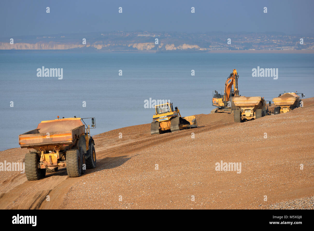 Schwere Maschinen verschieben Kies Strand auf Seaford, East Sussex, nach der jährlichen Winterstürme den Strand erodieren. Stockfoto