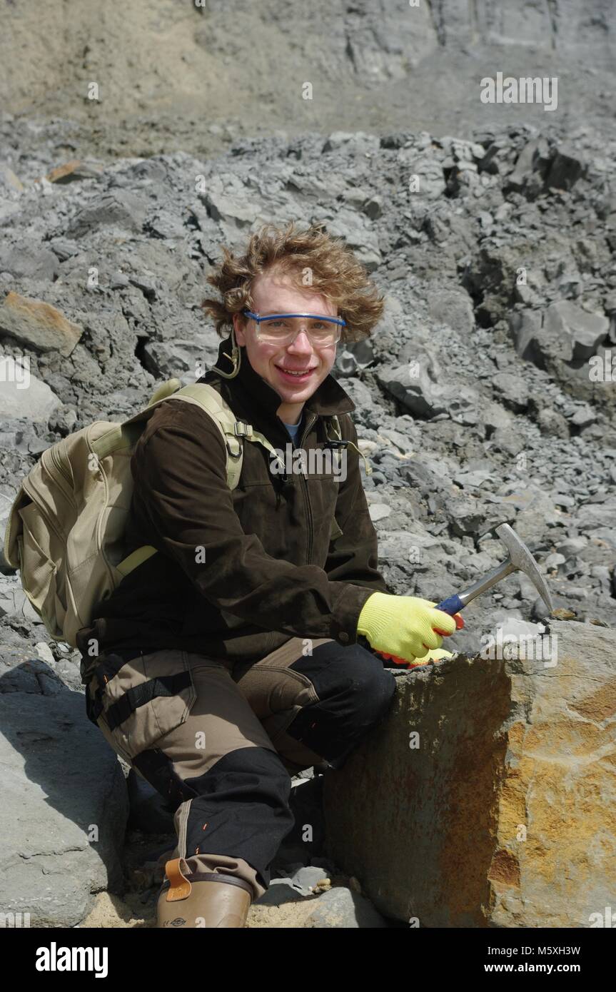 Junger britischer Geologe, Fossiliensuche auf Charmouth Beach, West Dorset. Weltnaturerbe Jurassic Coast, UK. Stockfoto