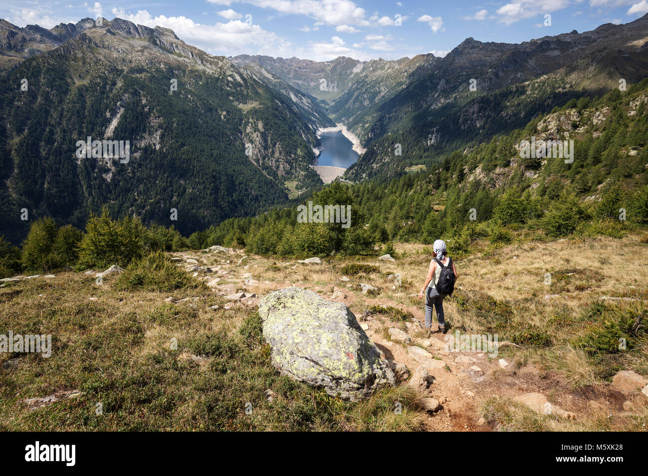 Wanderer auf dem Wanderweg von der Alpe Corte del Sasso bis Alpe Corte di Mezzo, in der Rückseite Sambuco, Lago di Sambuco, Fusio Stockfoto