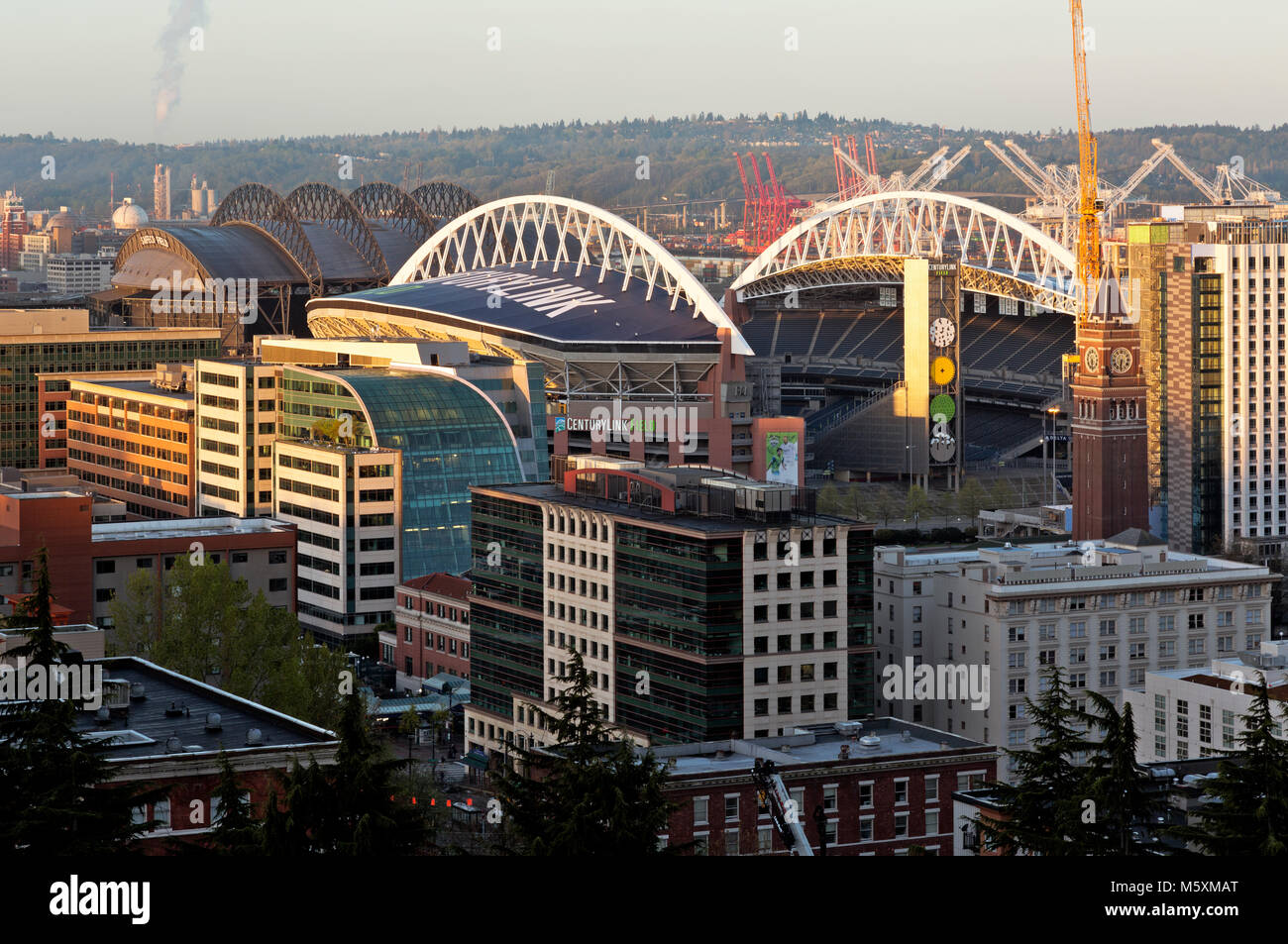 WASHINGTON - Sonnenaufgang Blick über das Internationale Viertel, die King Street Clock Tower, CenturyLink Feld und Safeco Field zu West Seattle. Stockfoto