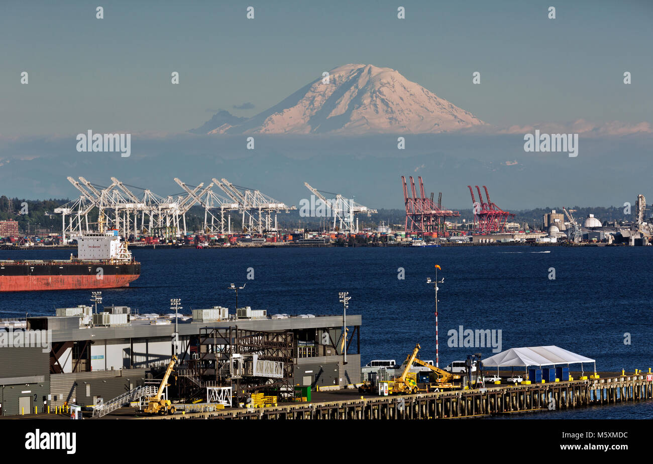 WA13729-00...WASHINGTON - Blick auf Mt. Rainier, Elliott Bay und die Kräne zum Be- und Entladen der Containerschiffe an der Seattle Waterfront. 2017 Stockfoto