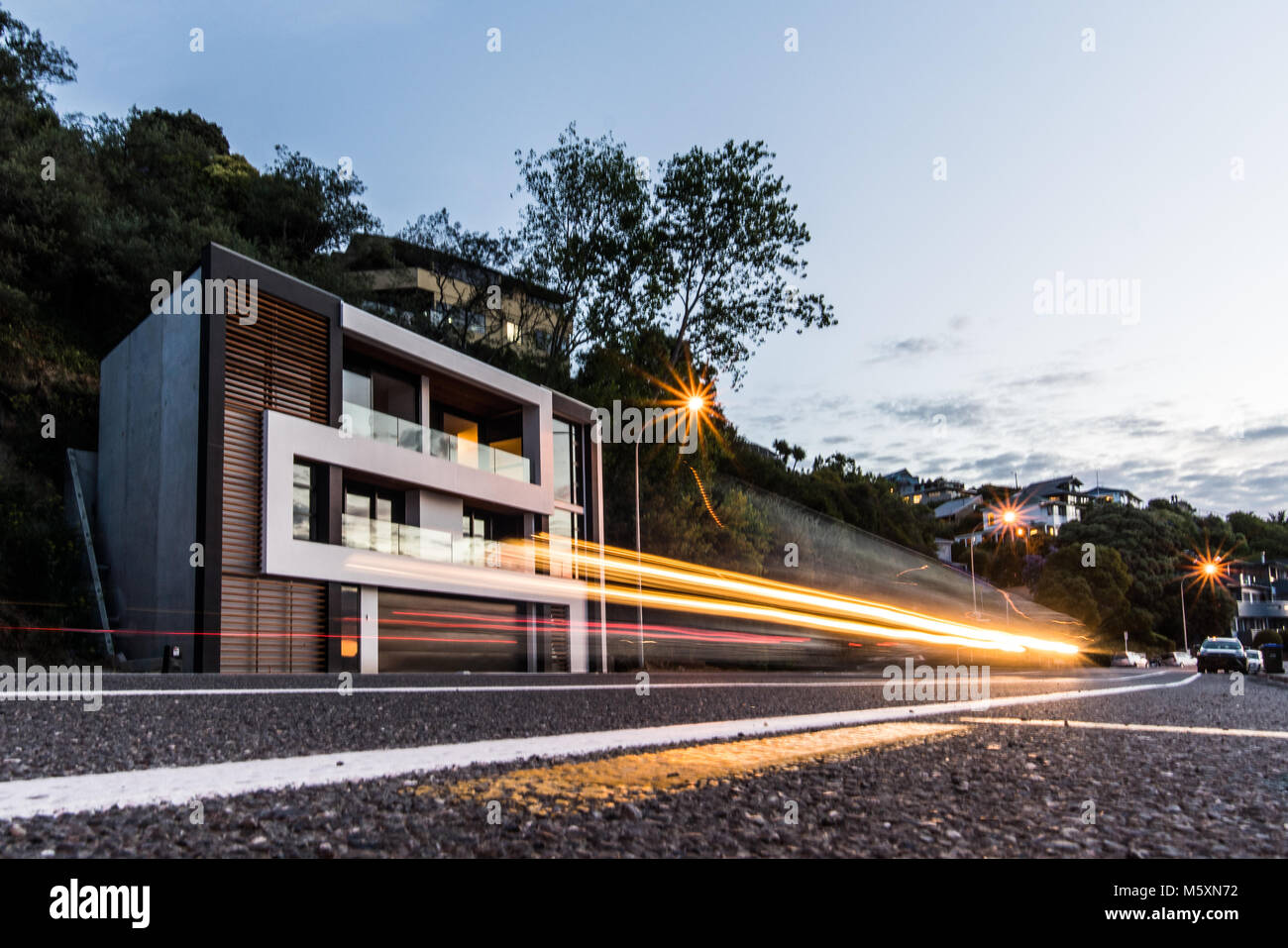 Auto beschleunigt, indem sie in der Dämmerung, leichte Wanderwege, modernes Haus und Nachbarschaft im Hintergrund Stockfoto