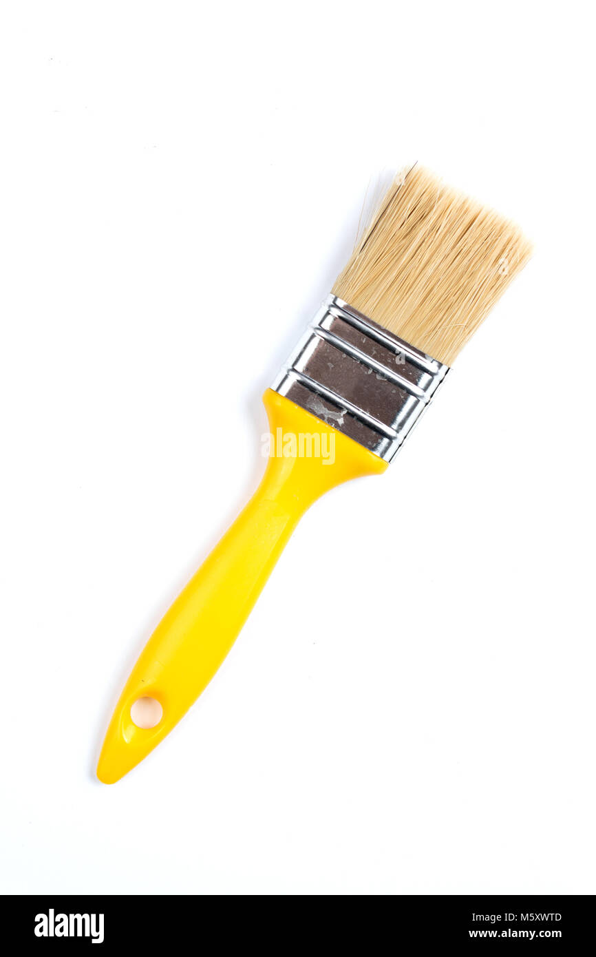 Gelbe Farbe und Pinsel auf einem weißen Hintergrund. Industrielle Pinsel mit Holzgriff. Stockfoto