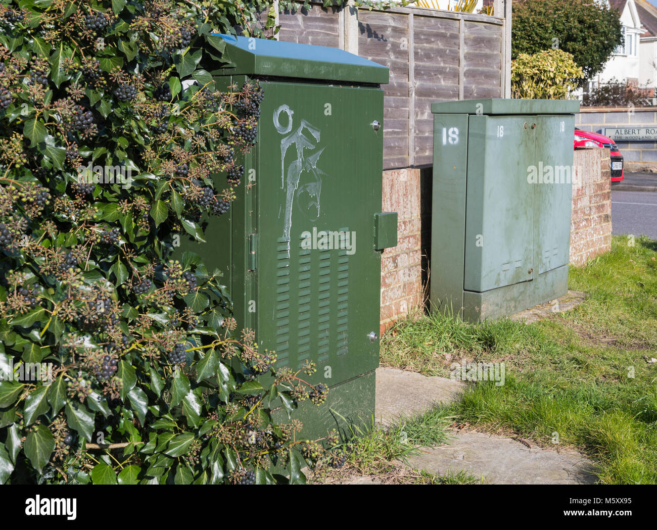 Paar grüne British Telecom Telefon Schränke an einer Straßenecke in England, Großbritannien. Stockfoto