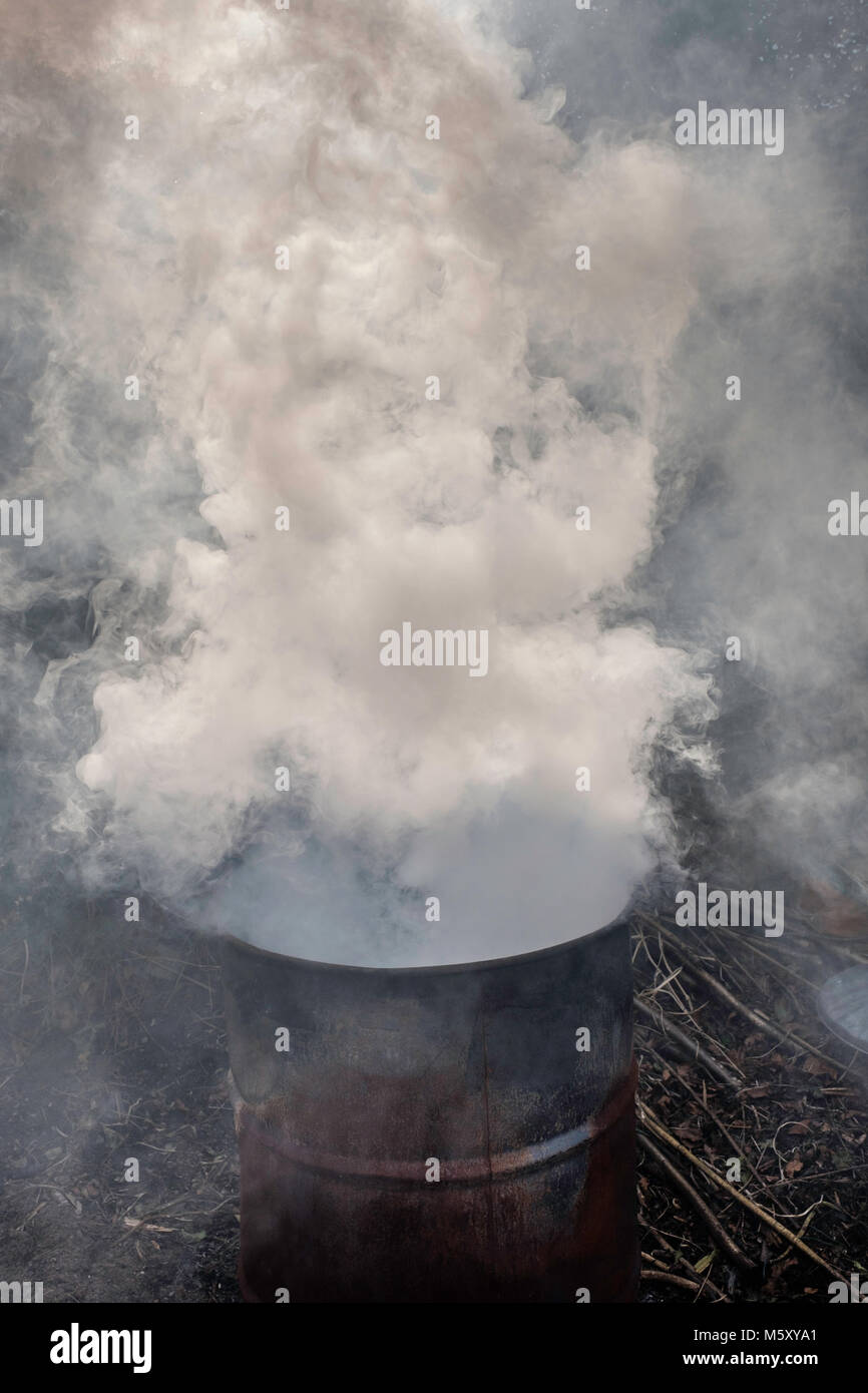 Gartenabfälle verbrennen in Metall im heimischen Garten drum, Gloucestershire England Großbritannien Stockfoto