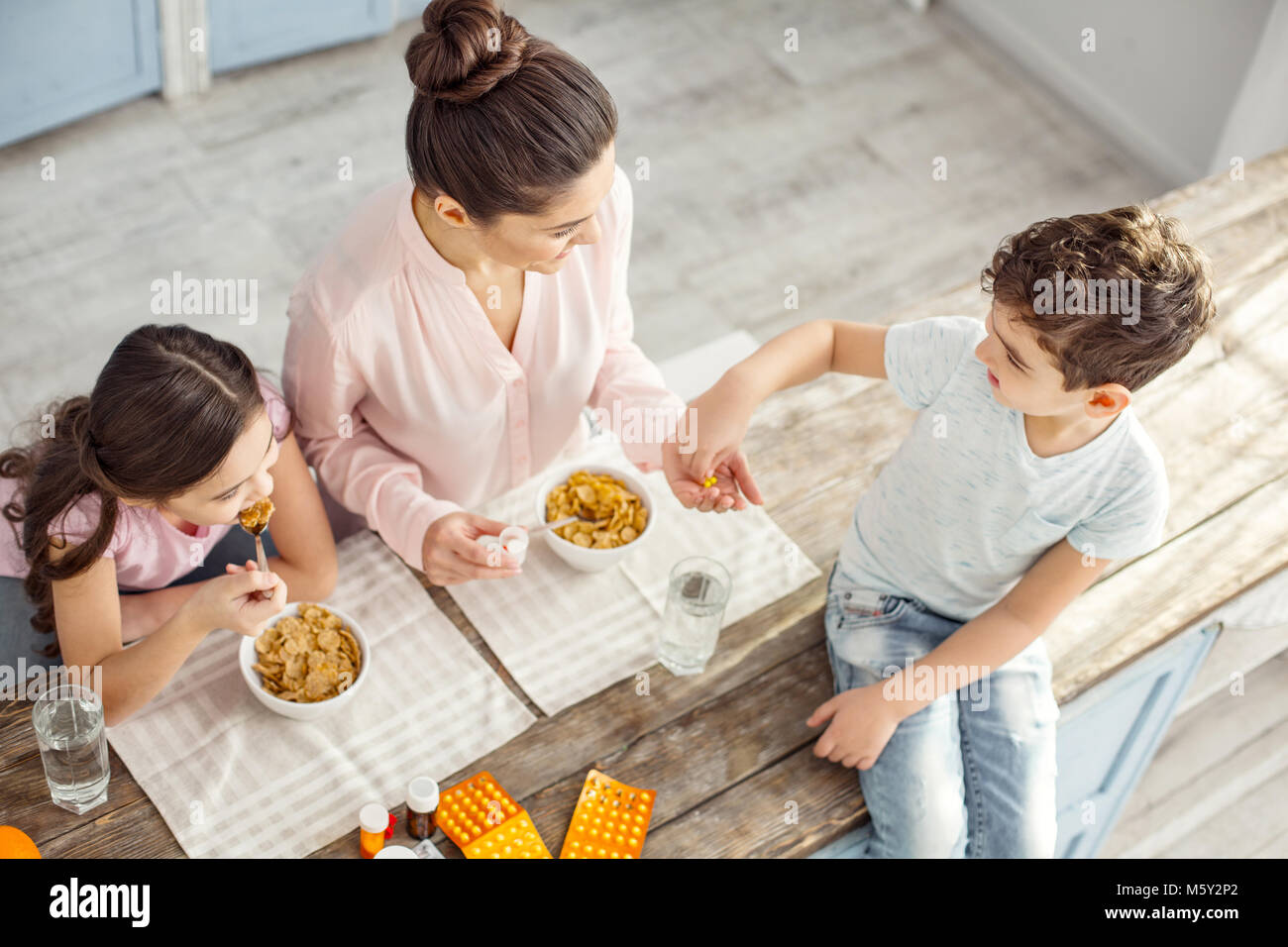 Slim Mutter Vitamine geben Sie Ihrem Sohn Stockfoto