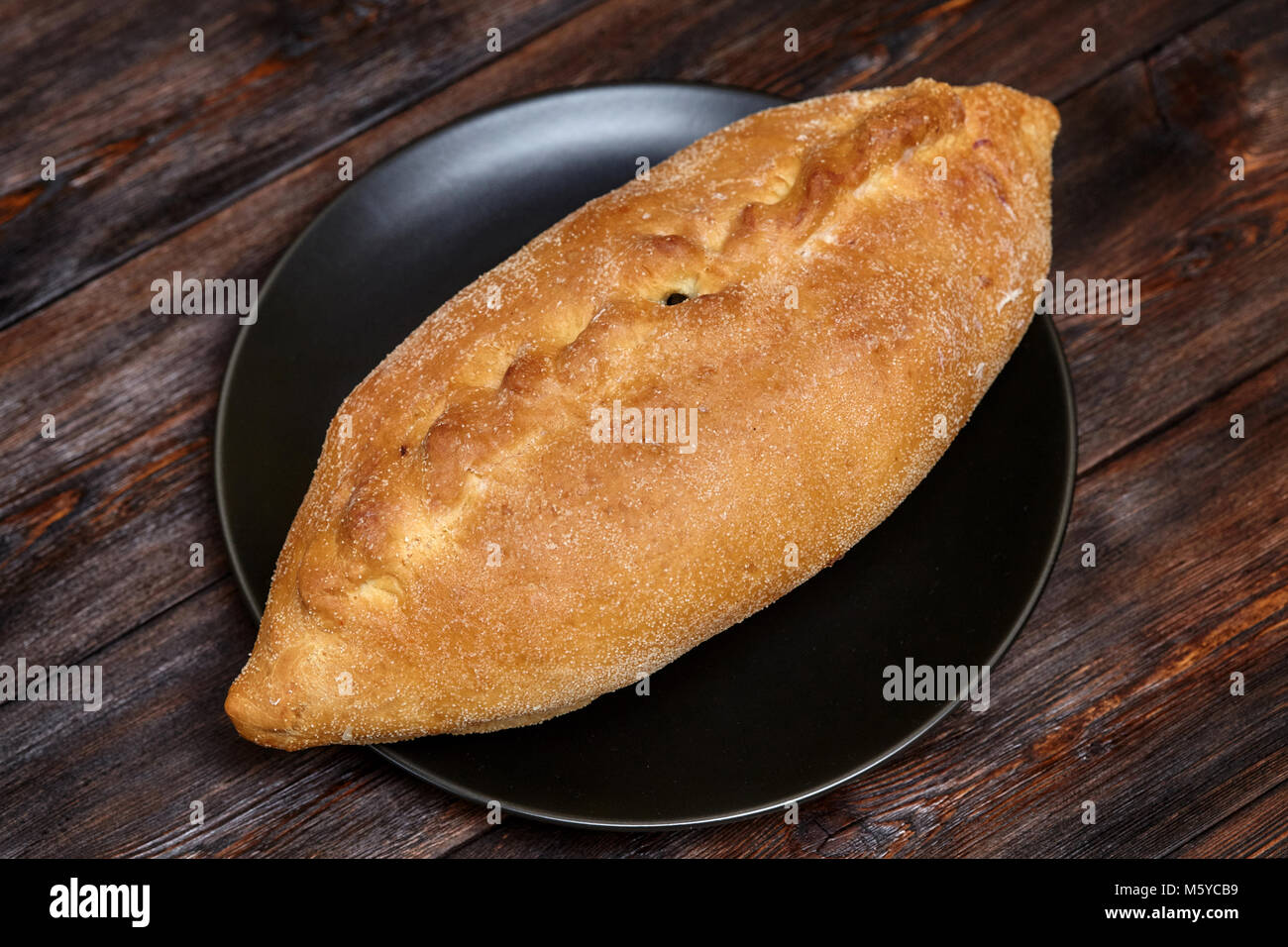 Leckere frische hausgemachte Kuchen mit Fisch adn Kartoffel auf schwarze Platte, dunklen, Hintergrund, Nahaufnahme Stockfoto