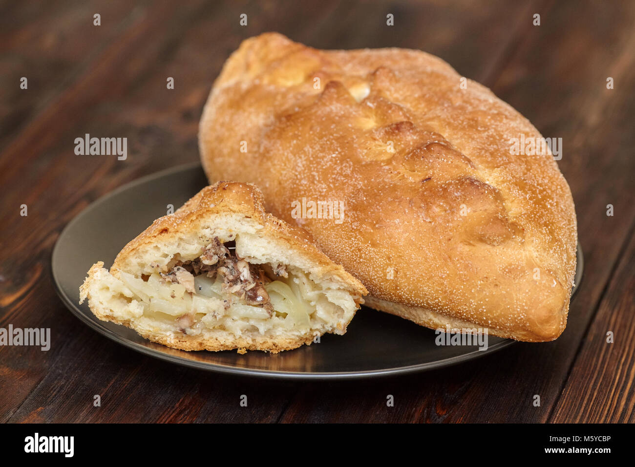 Leckere frische hausgemachte Kuchen mit Fisch adn Kartoffel auf schwarze Platte, dunklen, Hintergrund, Nahaufnahme Stockfoto