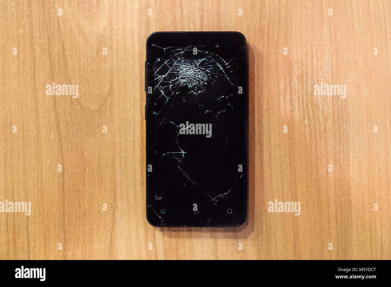 Smartphone mobile mit einem defekten Bildschirm. Hintergrund Holz Stockfoto