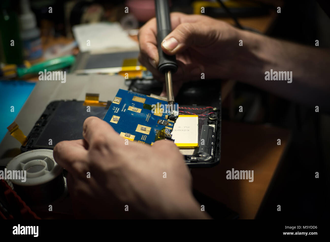 Hände halten einen Lötkolben, close-up. Handy Reparatur und Tablet Stockfoto