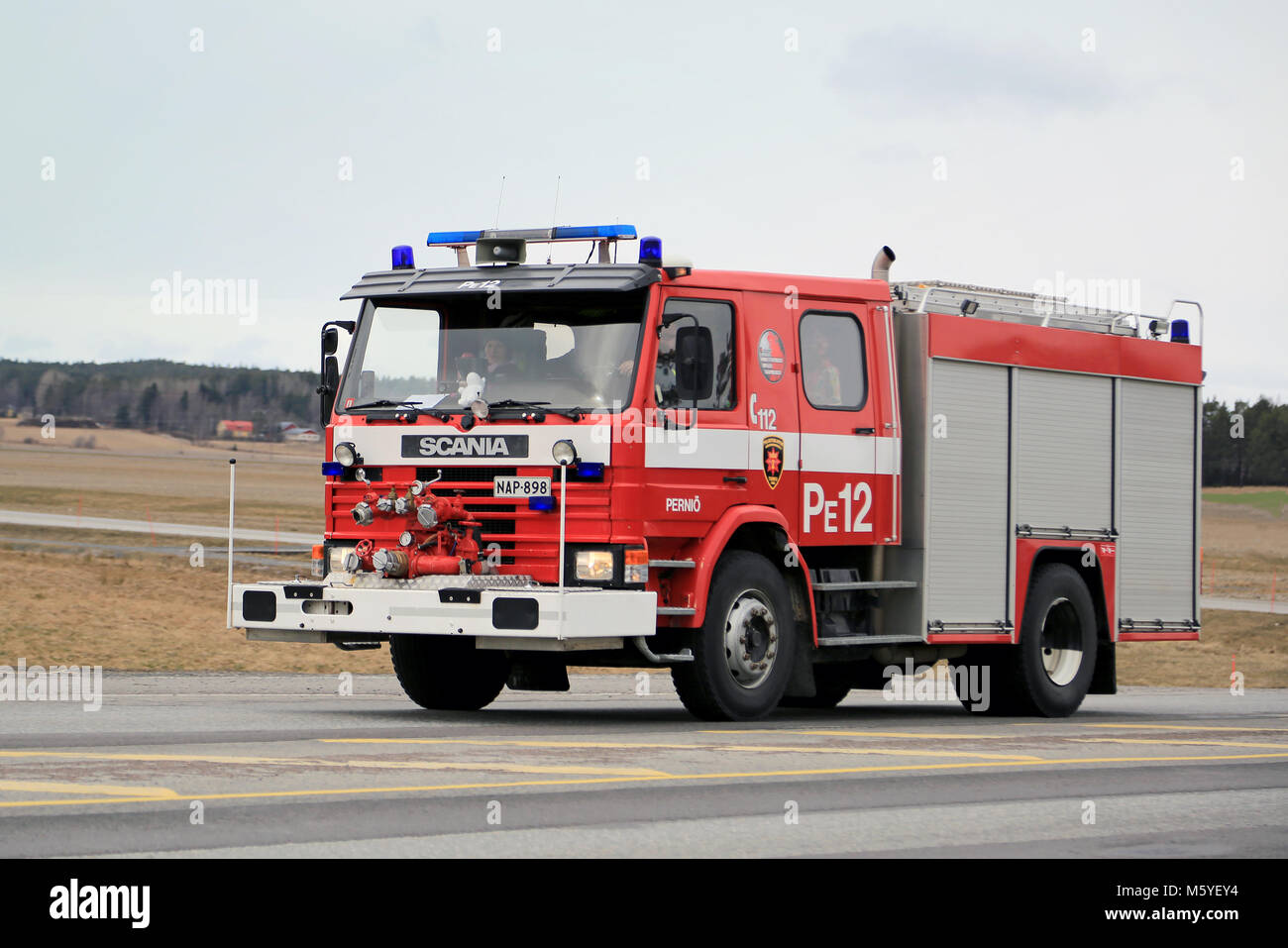 SALO, Finnland - 22. MÄRZ 2015: Klassische Scania Feuerwehrauto eilt entlang der Autobahn 25. Scania Löschfahrzeuge wurden von finnischen Feuerwehren für o verwendet. Stockfoto