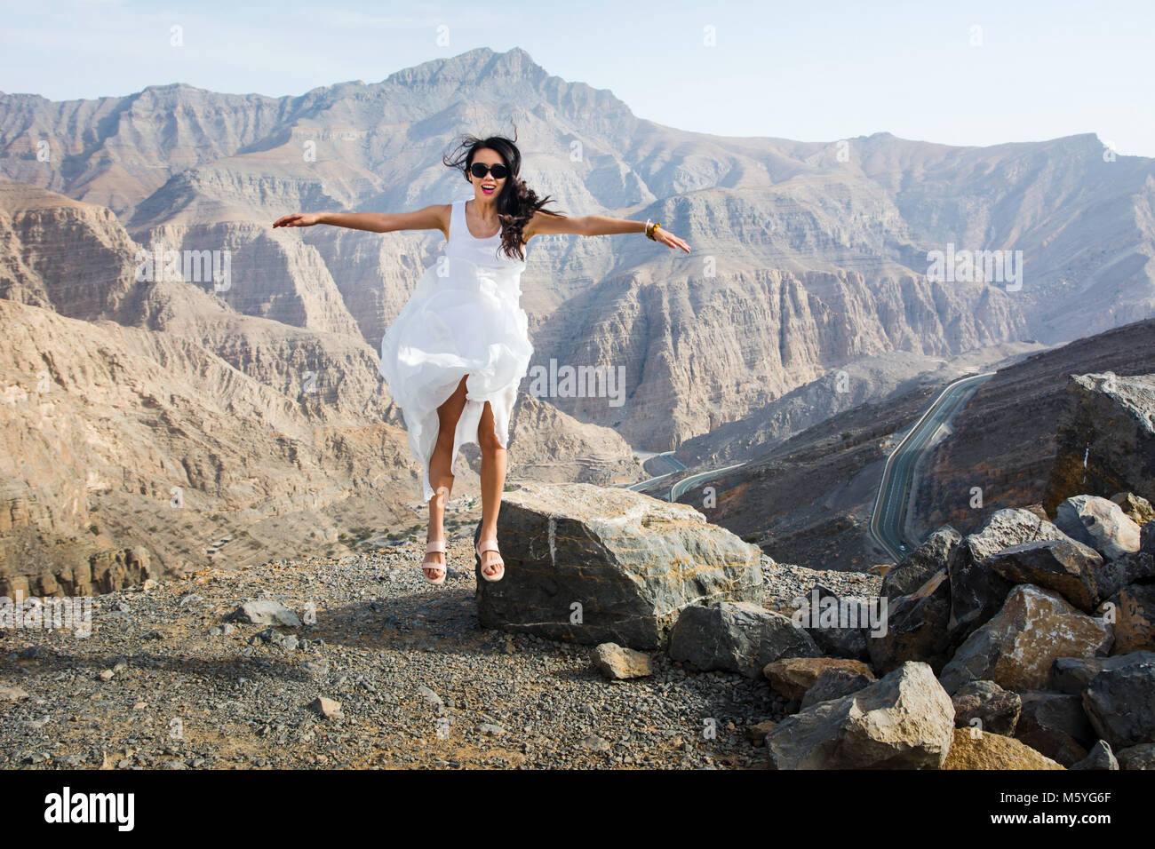 Happy girl Jumping auf dem Berg mit Aussicht Stockfoto