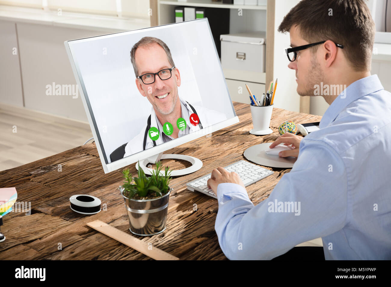 Junge Unternehmer Videokonferenzen mit dem Lächeln männlicher Arzt auf dem Computer im Büro Stockfoto