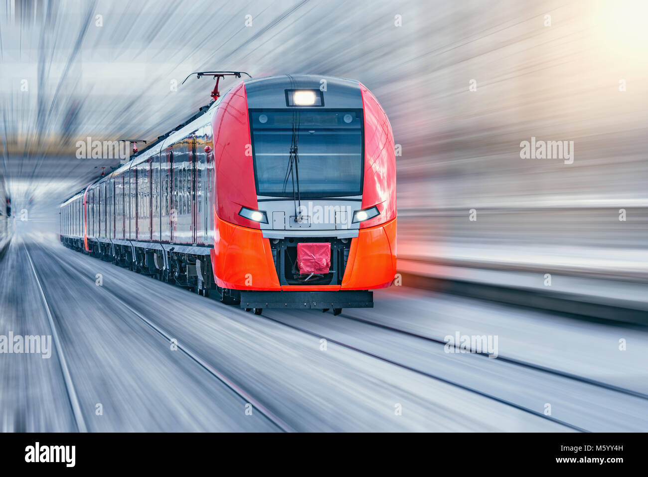 Moderne Hochgeschwindigkeitszug bewegt sich schnell im Winter abends Zeit. Stockfoto