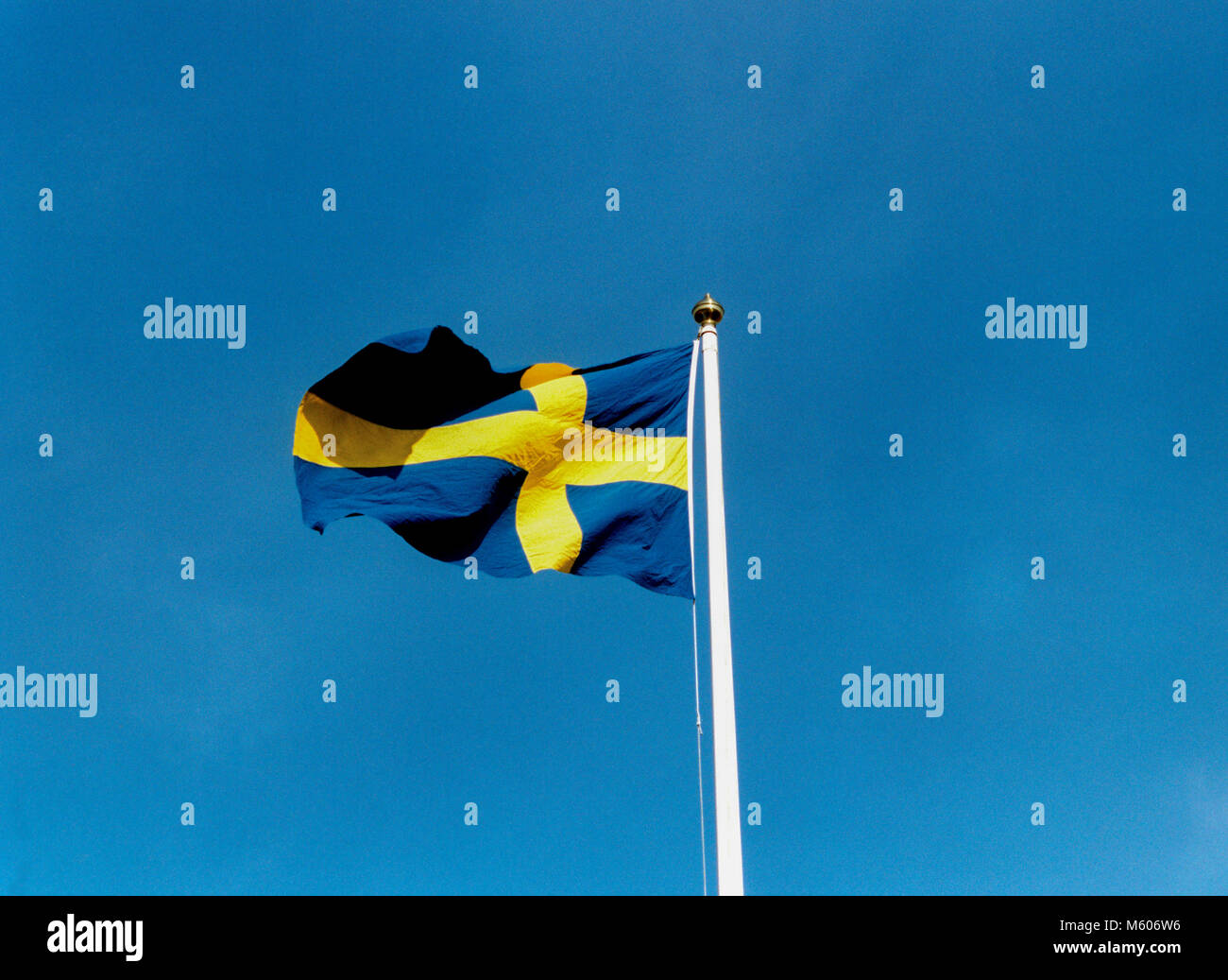 Schwedische Flagge am Fahnenmast vor blauem Himmel Stockfoto