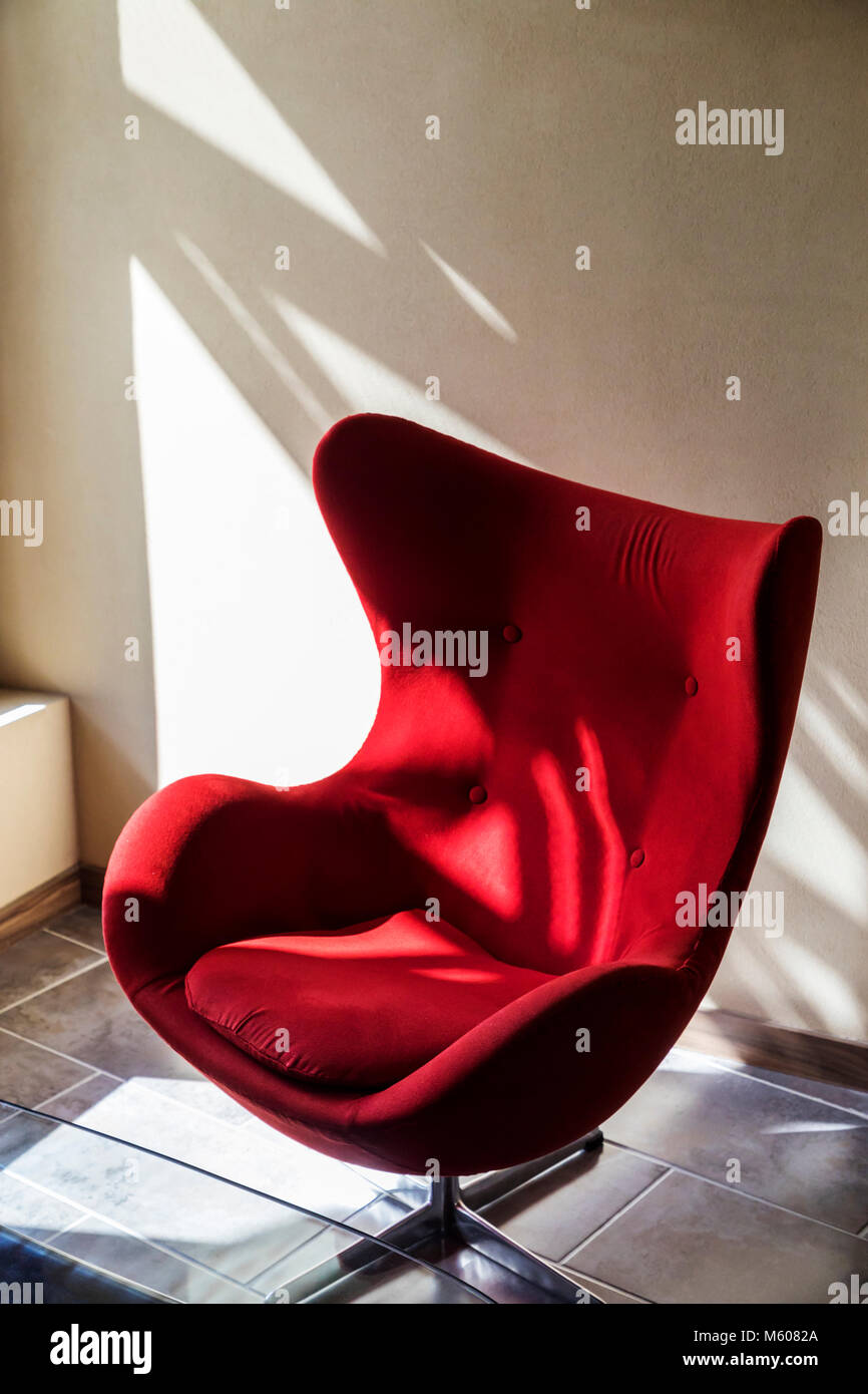 Interessante Spiel von Licht und Schatten auf einer gekrümmten roten Stuhl Stockfoto