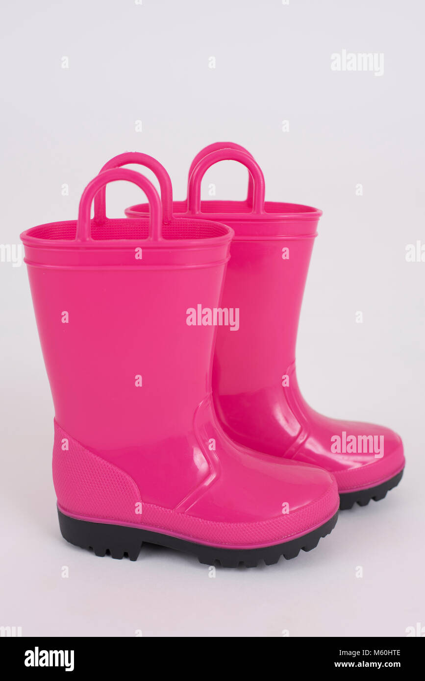 Ein paar der rosa Kinder regen Stiefel auf einem weißen Hintergrund. Stockfoto