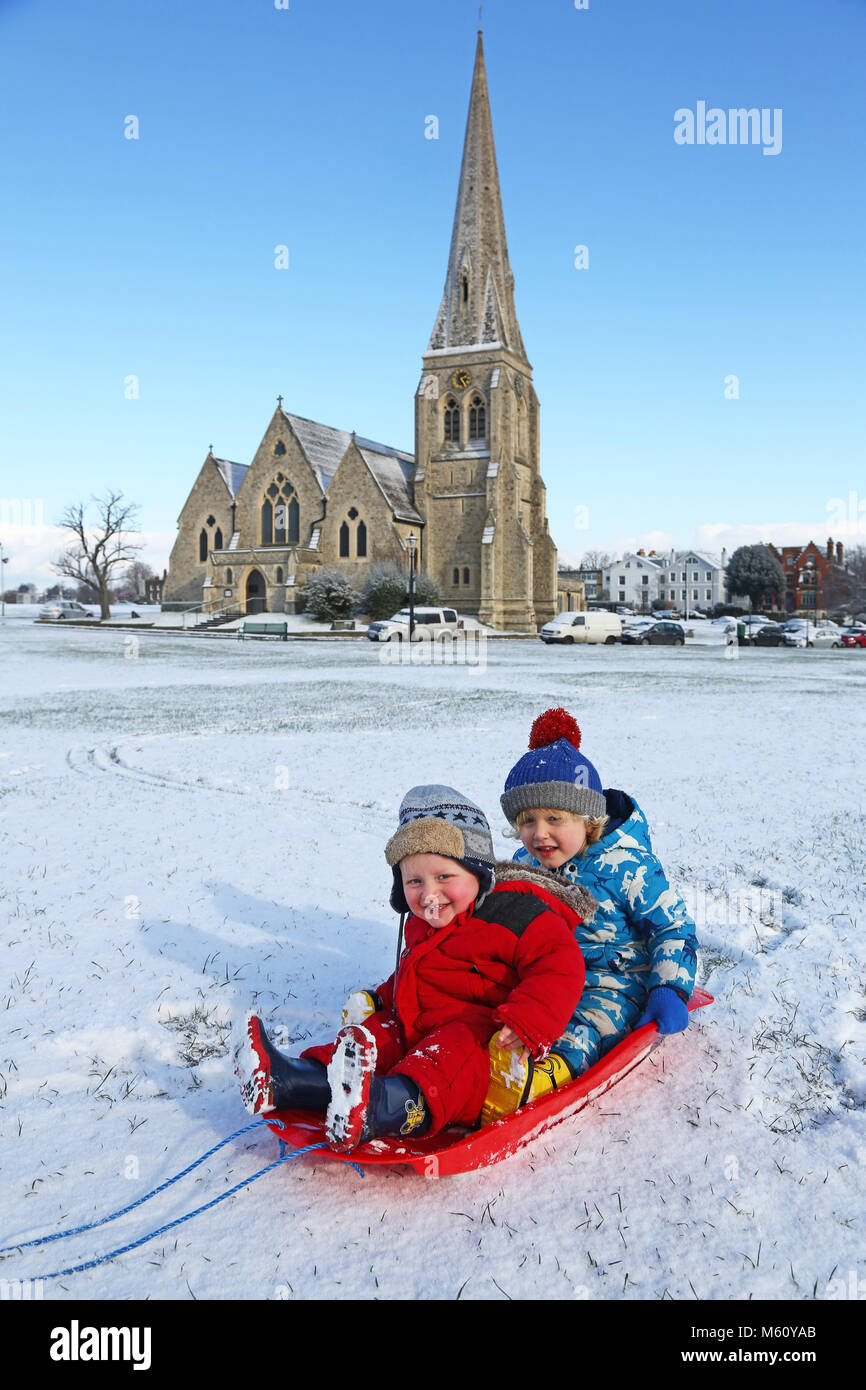 London, Großbritannien. 27. Februar 2018. Finley, im Alter zwischen 3 und Albee, im Alter zwischen 1 Spielen in ihrem Schlitten vor Allerheiligen Kirche während der verschneiten Wetter in Blackheath, London: Paul Brown/Alamy leben Nachrichten Stockfoto