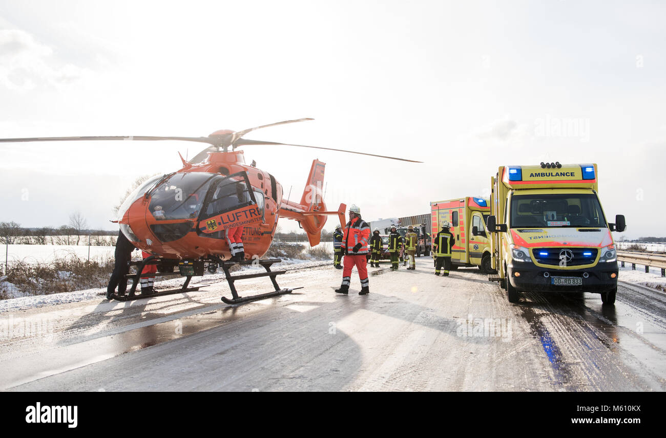 Talkau, Deutschland. 27 Feb, 2018. Ein Hubschrauber und ein Krankenwagen stehen auf der Autobahn 24 nach dem eisigen Straßen mehrere Kollisionen verursacht. Mehrere Personen wurden bei dem Unglueck verletzt. Foto: Daniel Bockwoldt/dpa Quelle: dpa Picture alliance/Alamy leben Nachrichten Stockfoto
