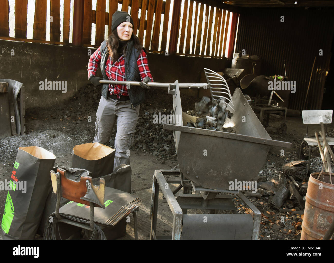 20 Februar 2018, Deutschland, Eisenhammer: Norma Austinat, Köhler, bekannt als 'Koehlerliesel' füllt Grill Kohle in Säcken die traditionelle Holzkohle Werke Eisenhammer in der dueben Heide vor Ort. Foto: Waltraud Grubitzsch/dpa-Zentralbild/dpa Stockfoto