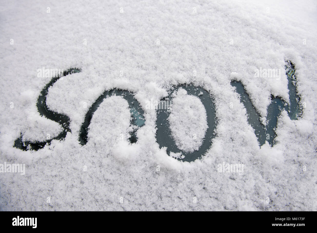 Jetzt' geschrieben, auf ein Auto Windschutzscheibe im Schnee bedeckt das Wort. Stockfoto