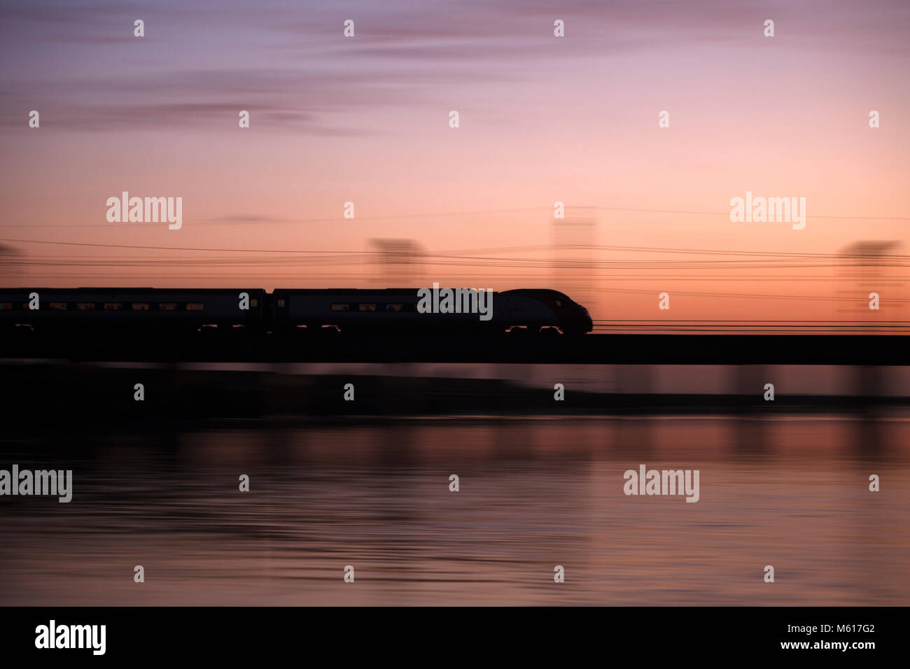 Ein Virgin Trains Pendolino Zuggeschwindigkeiten über den Fluss Esk bei Mossband (nördlich von Carlisle) mit einem Edinburgh nach London über Birmingham Zug Stockfoto