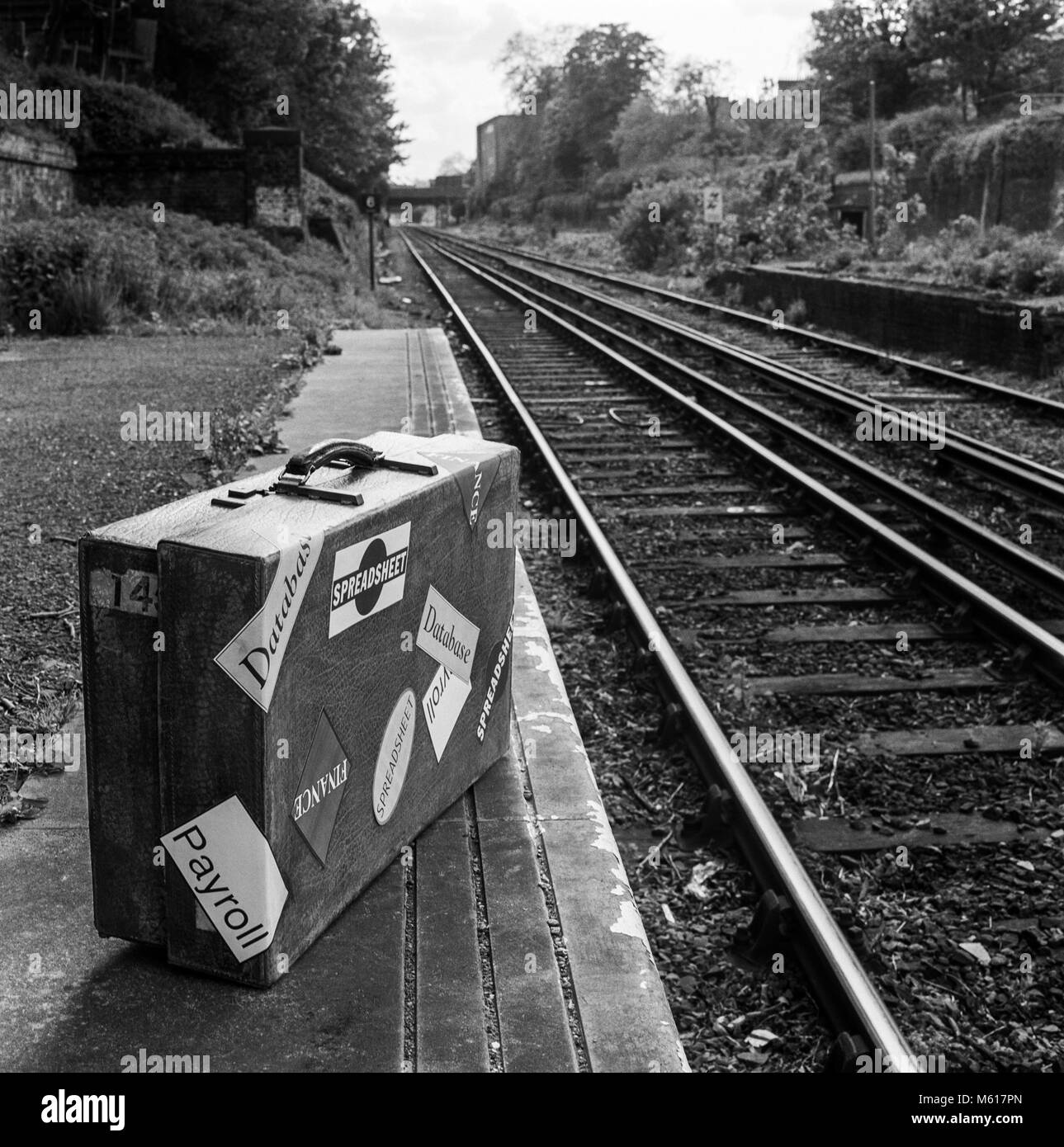 Koffer auf Bahnsteig mit Aufklebern, die sich auf finanzielle Produkte und Datenverarbeitung, Konzept für mobile, Teilen, Daten, Archivierung Foto am 11. Mai 1992 abgedeckt Stockfoto