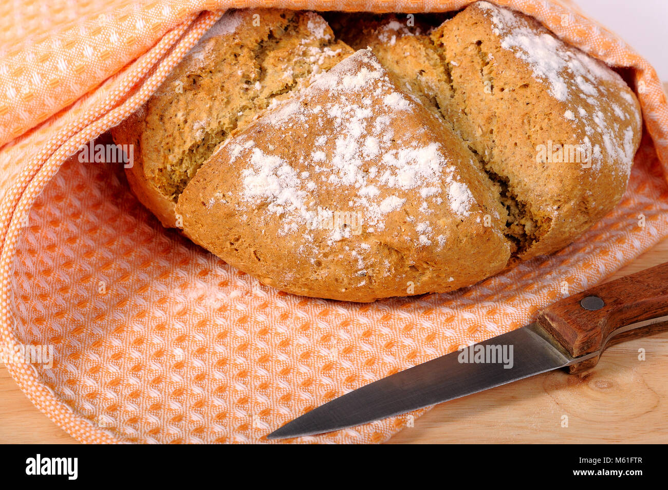 Frisch gebackenes Brot in ein Geschirrtuch und ein Messer Stockfotografie -  Alamy
