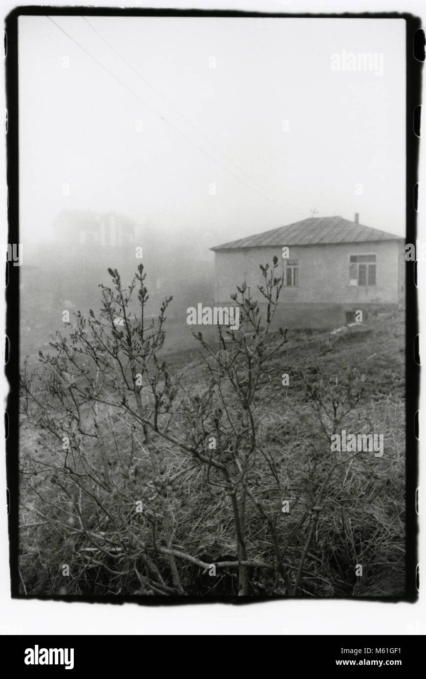 Ländliche Haus im Nebel. Bakuriani. Achtung! Das Bild enthält Granularität und andere Artefakte der analogen Fotografie! Stockfoto