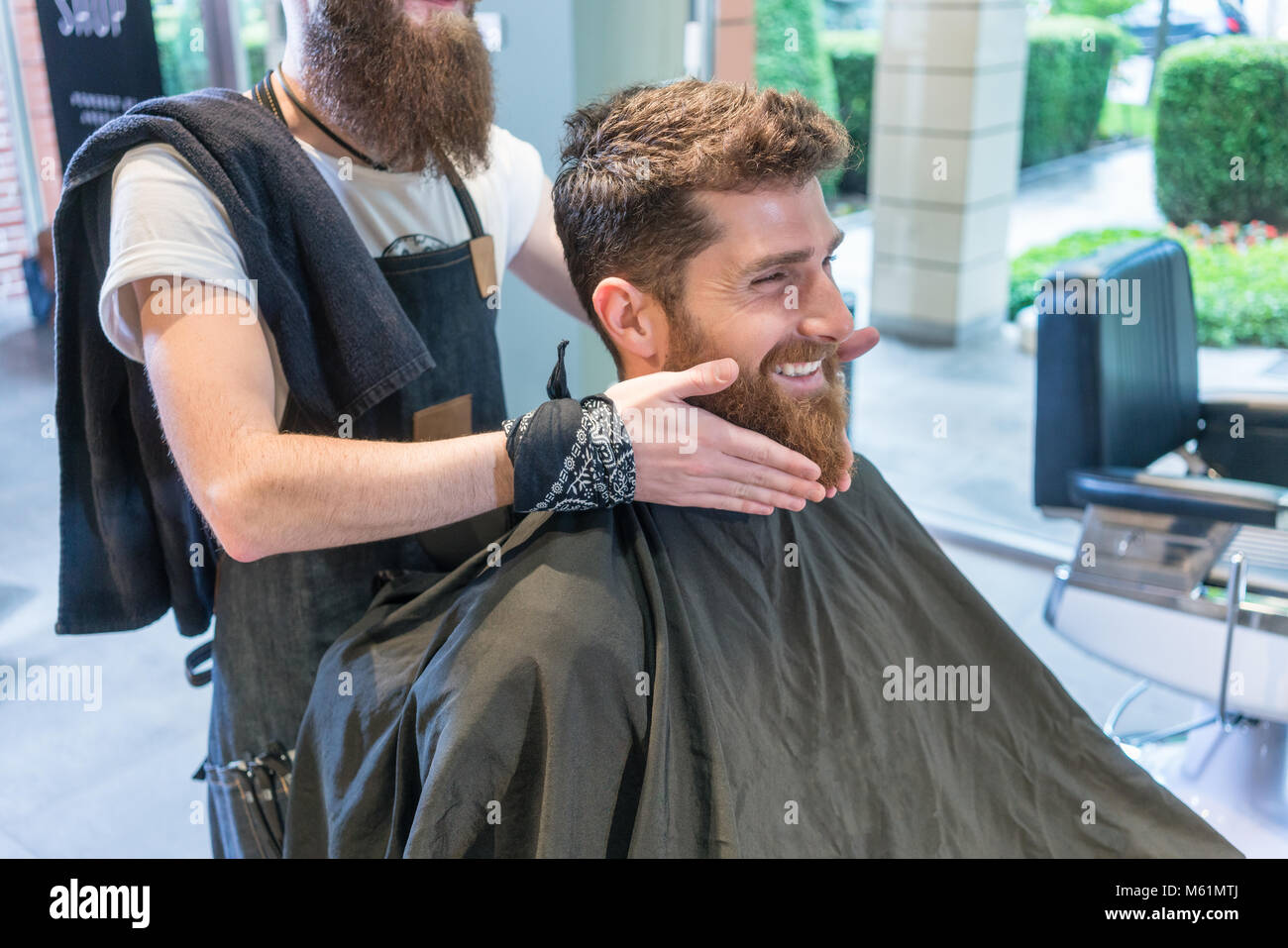 Hübscher junger Mann Denken an eine andere Form für seinen Bart Stockfoto