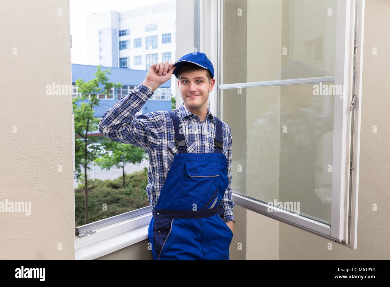 Porträt eines lächelnden Mann Heimwerker in der Nähe von Glas Fenster Stockfoto