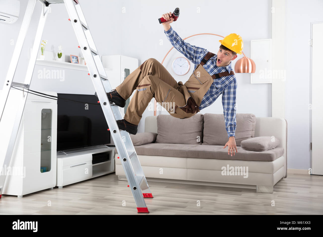 Junge männliche Tischler Fallen aus Metall Leiter im Wohnzimmer  Stockfotografie - Alamy