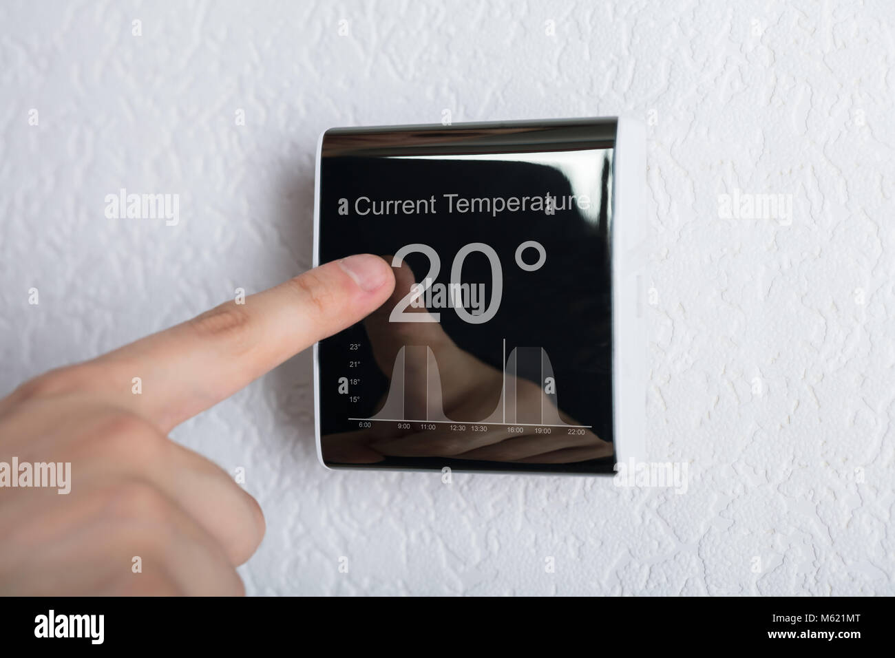 Finger berühren Digitaler Thermostat Temperaturregler zu Hause Stockfoto