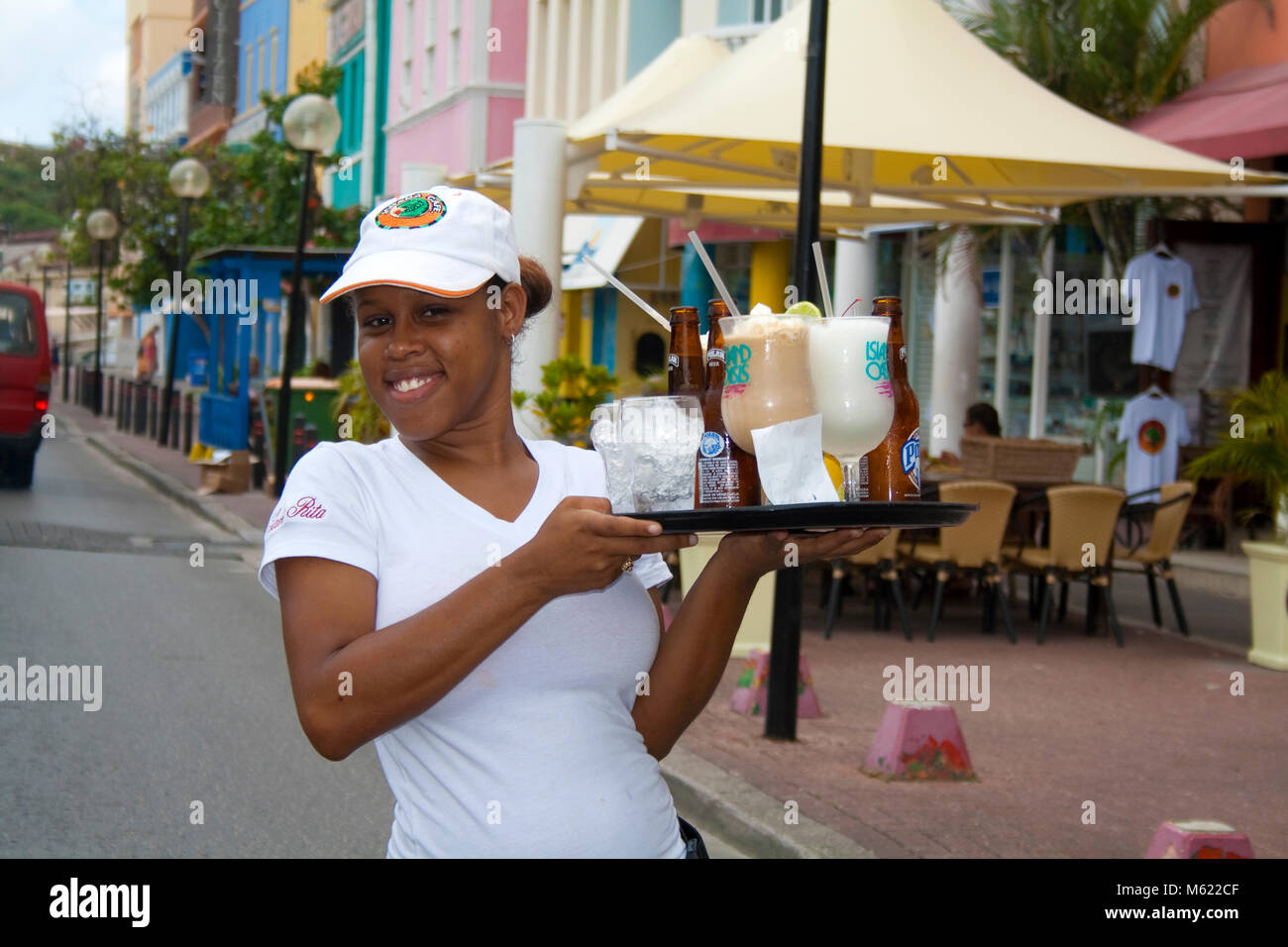 Freundliche Kellnerin Getränke im Waterfront von Punda, Willemstad, Curacao, Niederländische Antillen, Karibik serviert Stockfoto
