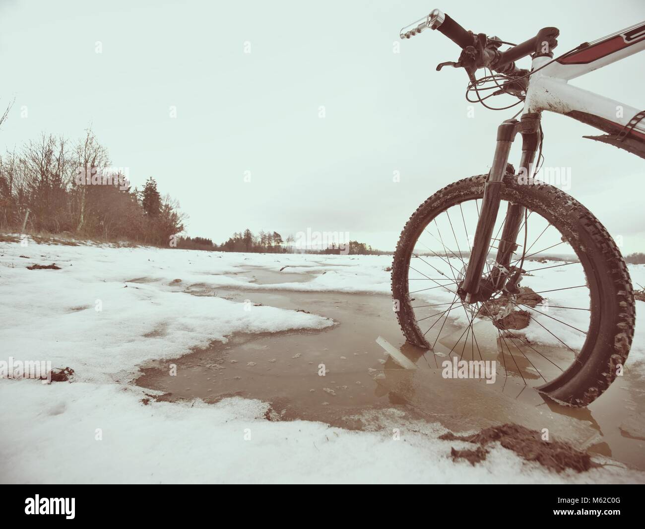 Mountainbike Rad brach durch das Eis ins Wasser. Winter Biken mit Spaß genießen Stockfoto