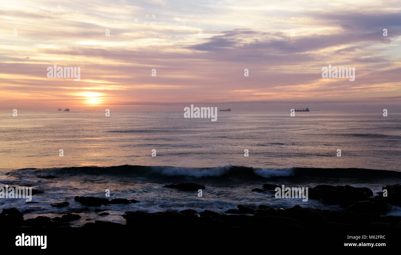 Landschaft, dramatischer Himmel, Durban, KwaZulu-Natal, Südafrika, Schöne Welle, Sonnenaufgang, Schiffe auf Indischen Ozean, Horizont, Umhlanga Rocks Strand, Meer Stockfoto