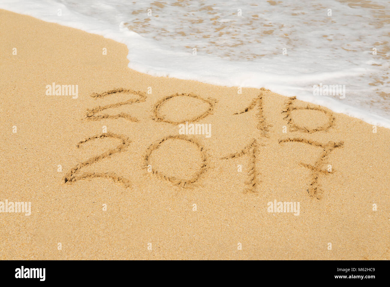 Ziffern 2016 und 2017 am Strand Sand - Begriff des neuen Jahres, Ferien-, Reise- und Lauf der Zeit. Stockfoto