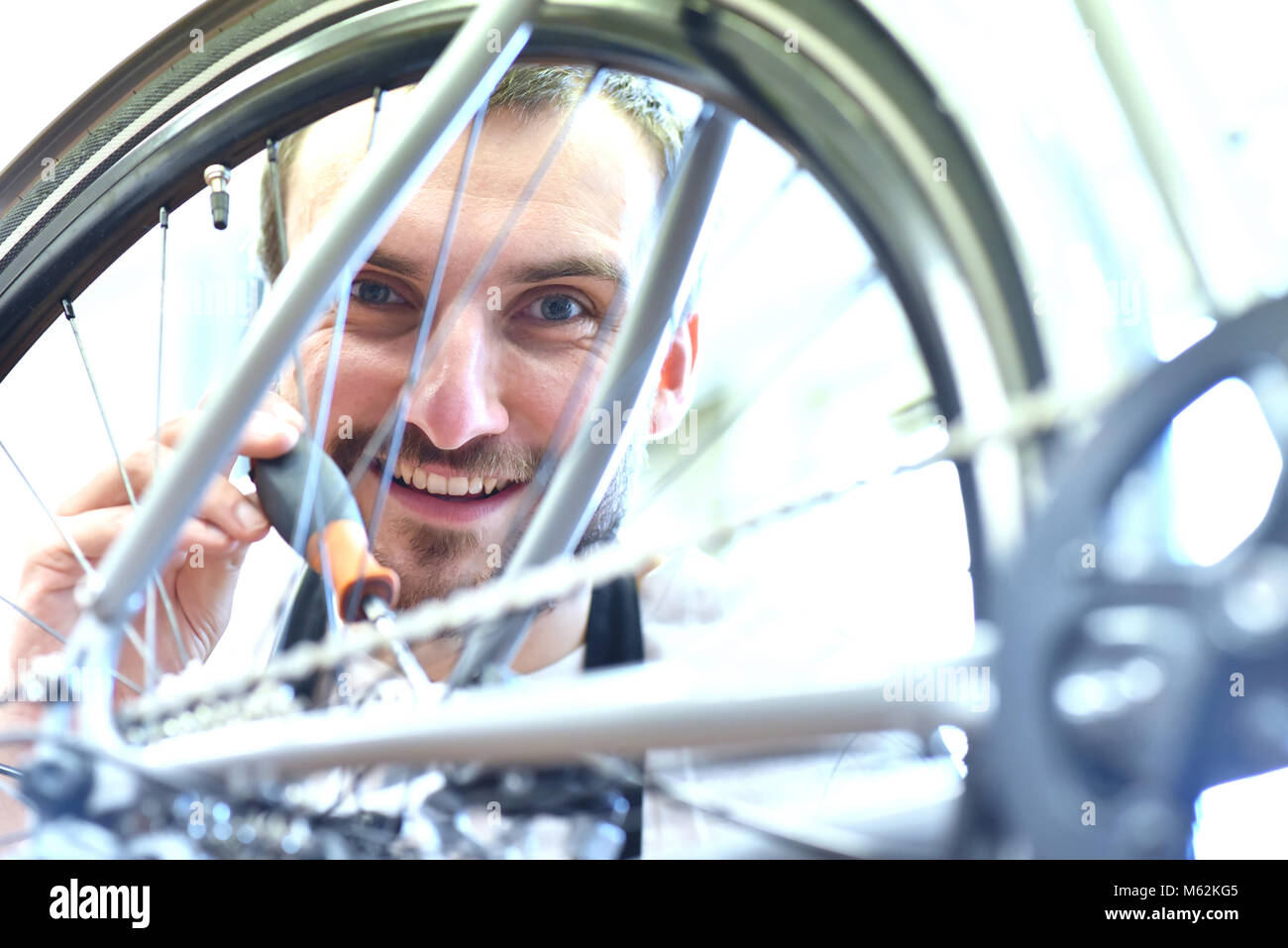 Mechaniker in einer Fahrradreparaturwerkstatt Ölen der Kette der ein Fahrrad Stockfoto