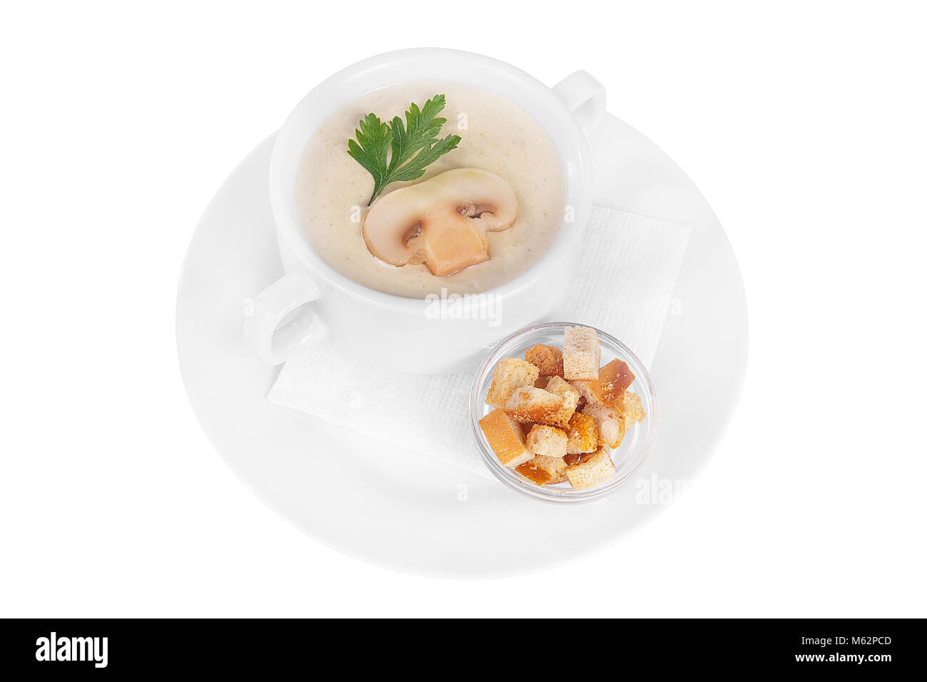 Suppe pürieren, creme Suppe weiß, beige mit Pilzen, championons und Cracker, trockenes Brot. Auf eine Serviette in einer weißen Platte isolierten Weiß. Ich Gerichte Stockfoto