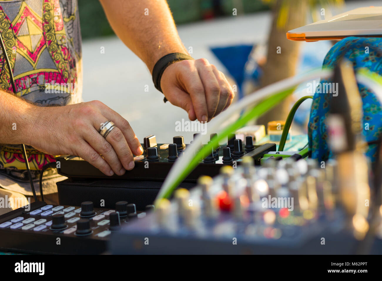 Schließen bis auf DJ Hände mit Silber Ring auf seinen Mittelfinger mischen Musik mit professioneller Ausstattung inklusive Konsole, Laptop und Leistungsverstärker Stockfoto