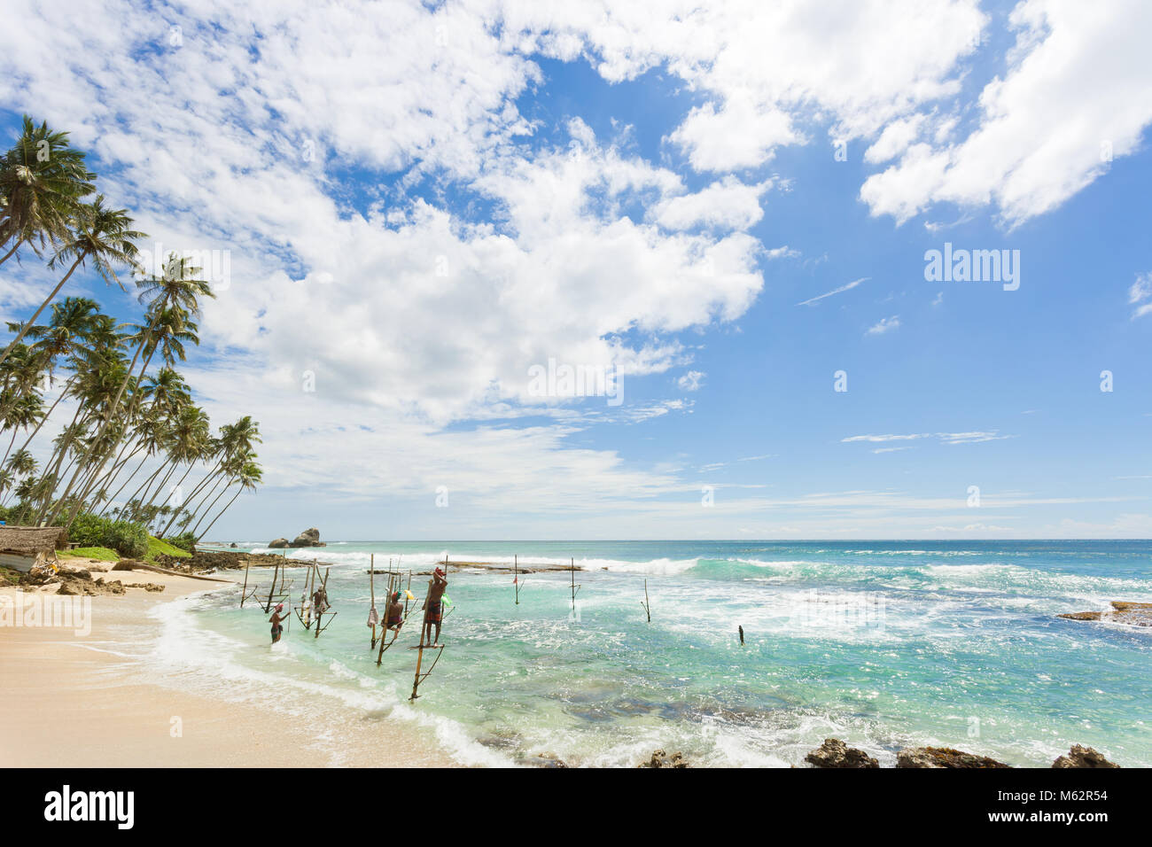 Koggala Beach, Sri Lanka, Asien - Dezember 2015 - Mehrere einheimische Fischer bei Koggala Beach üben ihre traditionelle Art und Weise der Stelze angeln Stockfoto