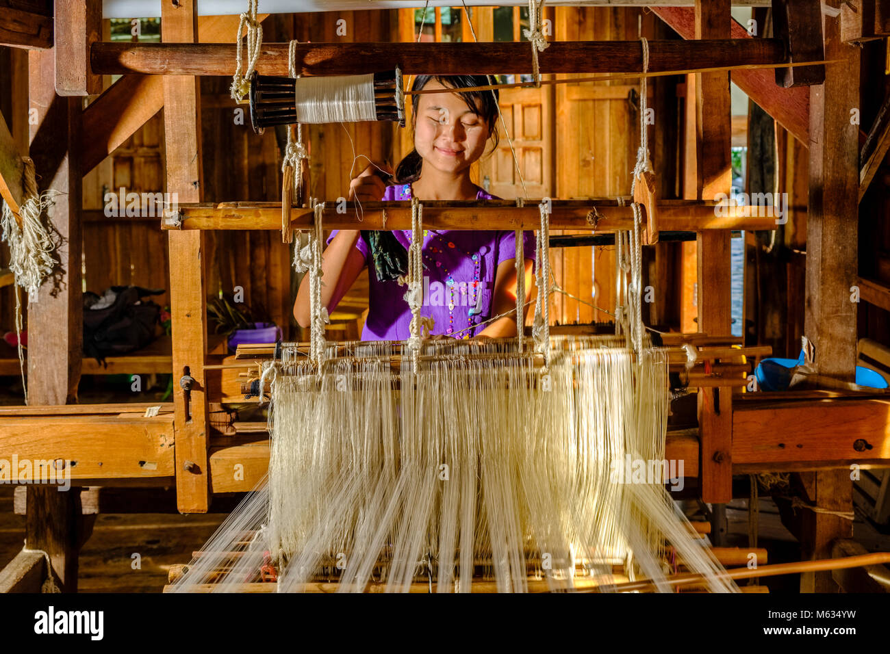 Lotus Fasern sind an Material auf einem handwebstuhl durch eine lokale Frau im Dorf Ywama auf einer Insel am Inle See gewebt Stockfoto