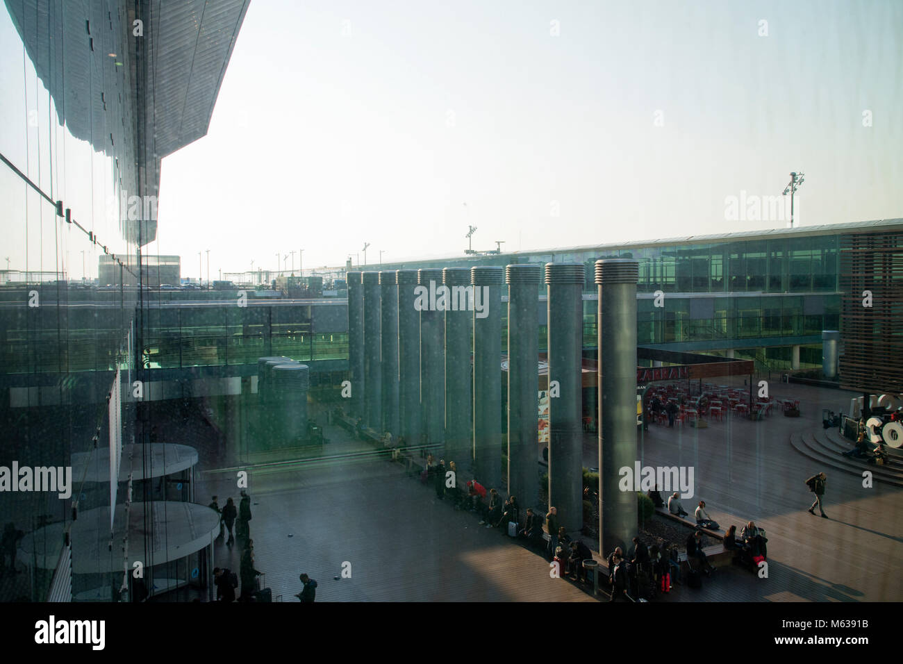 Die Passagiere genießen die Sonne in einem äußeren Bereich der Flughafen Barcelona Stockfoto
