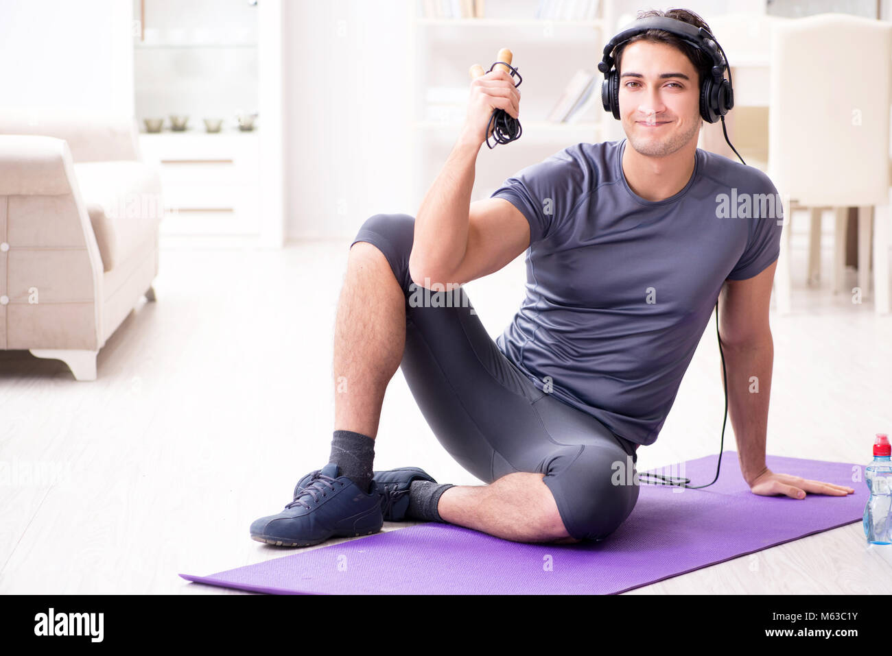 Mann Sport zu Hause und Hören von Musik Stockfoto