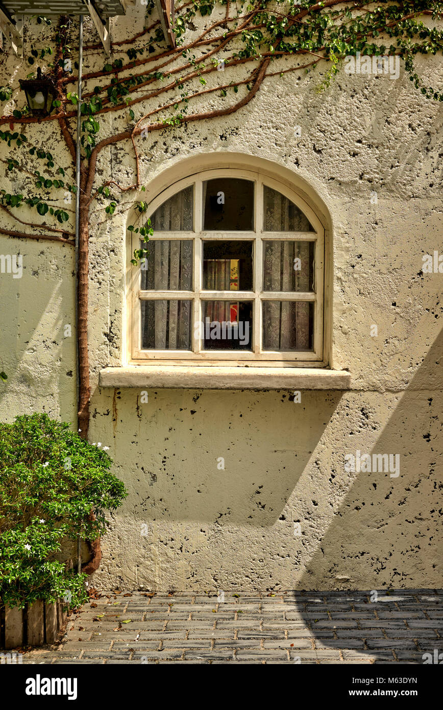 Gewölbte Fenster eines, aus Stein gebauten Ferienhaus zu Hause. Traditionelle Ferienhaus außen Stockfoto