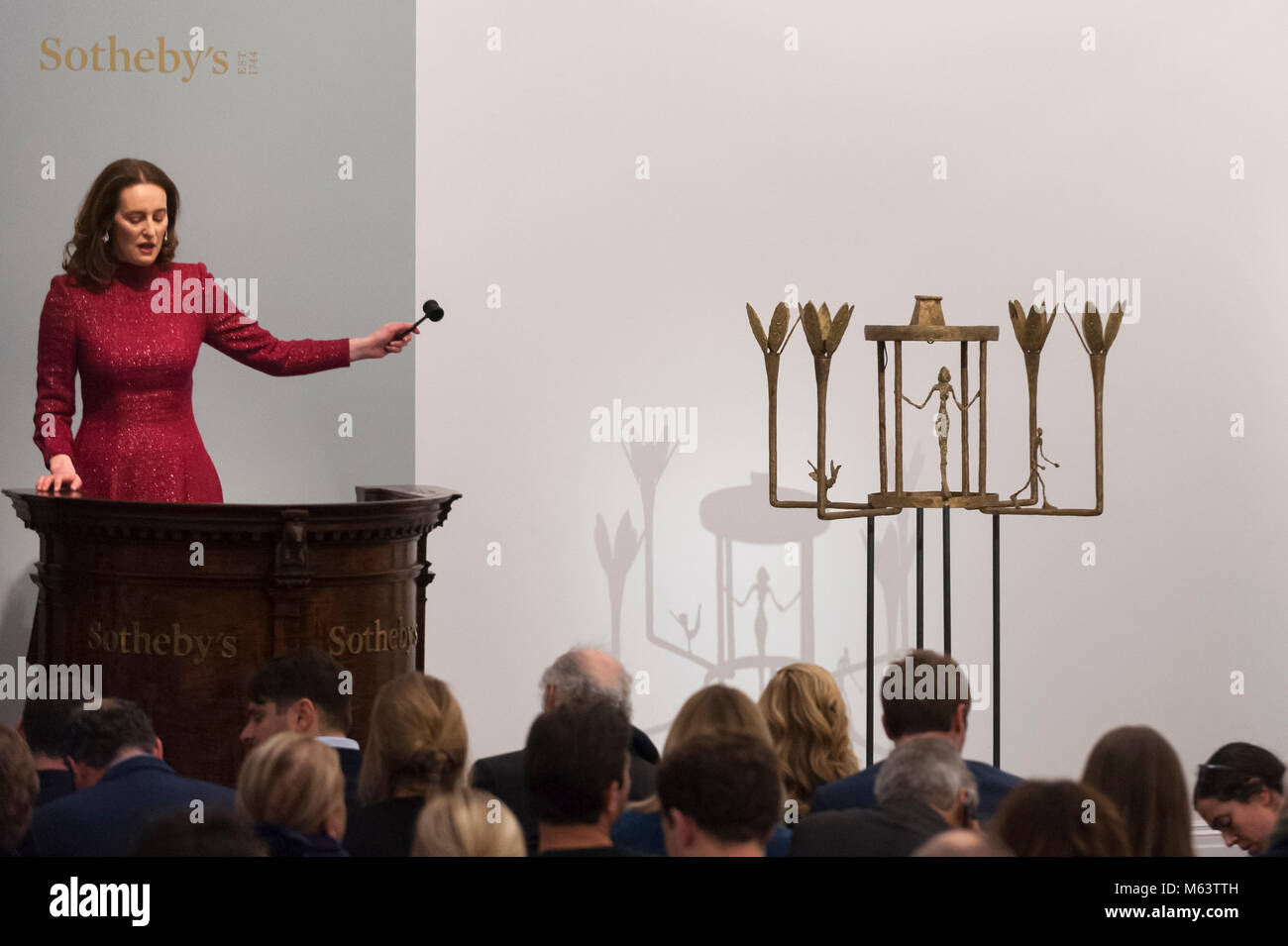 London, Großbritannien. 28. Februar 2018. Versteigerer Helena Newman verwaltet, Angebote für "Lustre Avec Femme, Homme et Oiseau'' von Alberto Giacometti, (Est. £ 6-8 m), die für einen Hammer Preis von £ 6,6 m am Abend Verkauf von Impressionistischen, moderner & Surrealistische Kunst bei Sotheby's in New Bond Street verkauft. Credit: Stephen Chung/Alamy leben Nachrichten Stockfoto