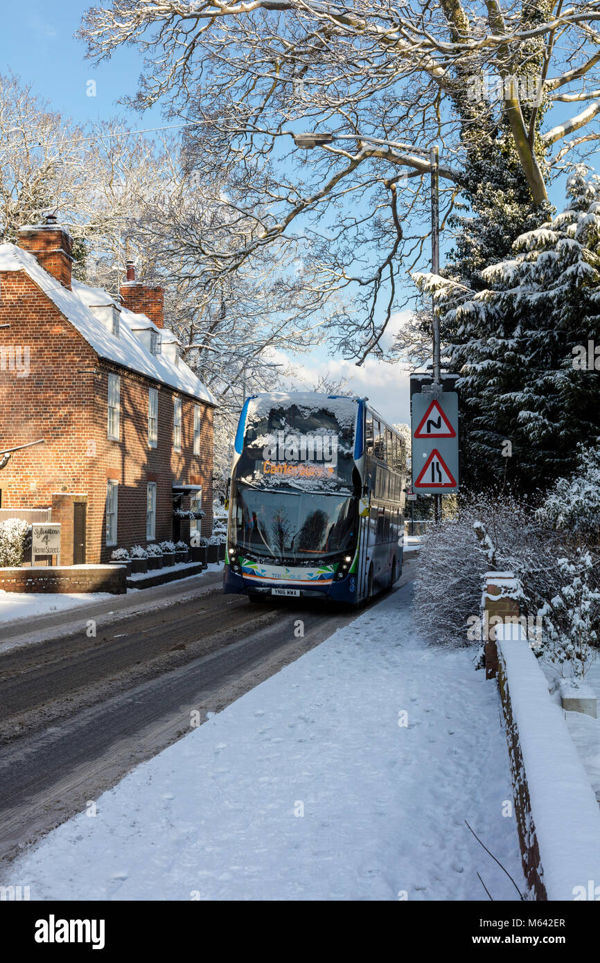 Herne, Kent, UK, 28. Februar 2018. UK Wetter Nachrichten: Nach einem starken Schneefall in der Canterbury Gebiet im Osten von Ken, Übernachtung. Die Sonne im Dorf Herne als Verkehr und Busse Kampf auf der 291 kommt, spielen die Kinder auf der Piste in den Schlitten. Richard Donovan/Alamy leben Nachrichten Stockfoto